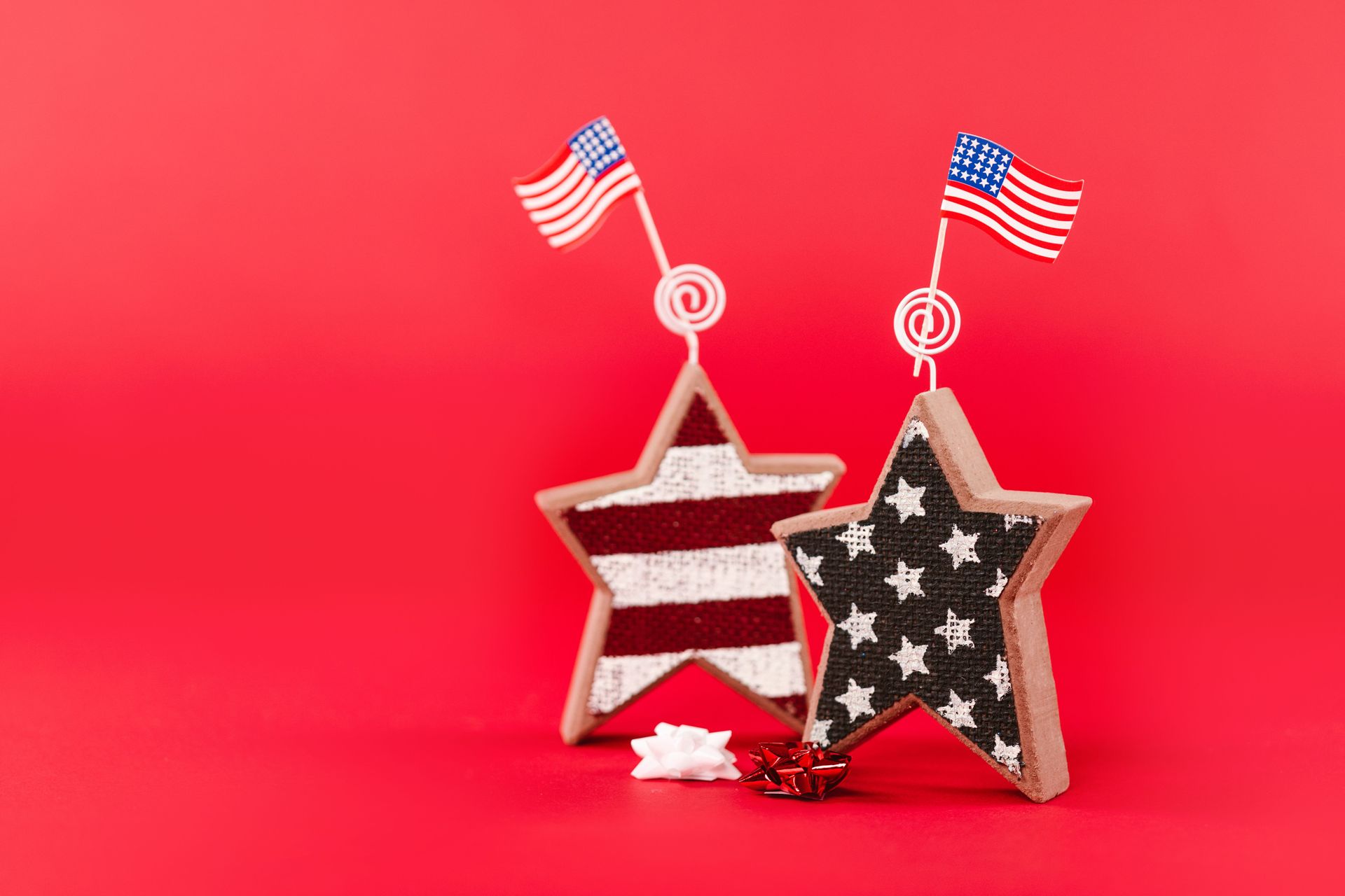 Red, white, and blue star ornaments with small American flags on a bright red background