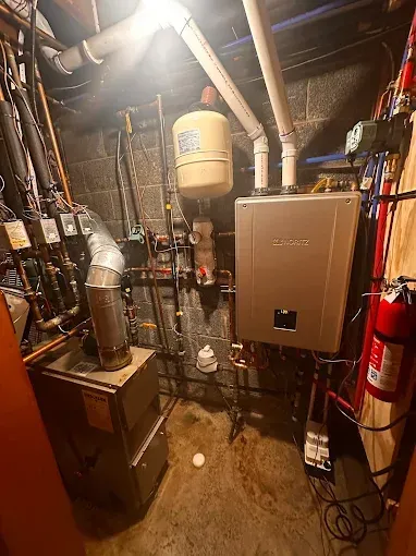 Basement with heating equipment including a water heater, boiler, pipes, and a fire extinguisher.