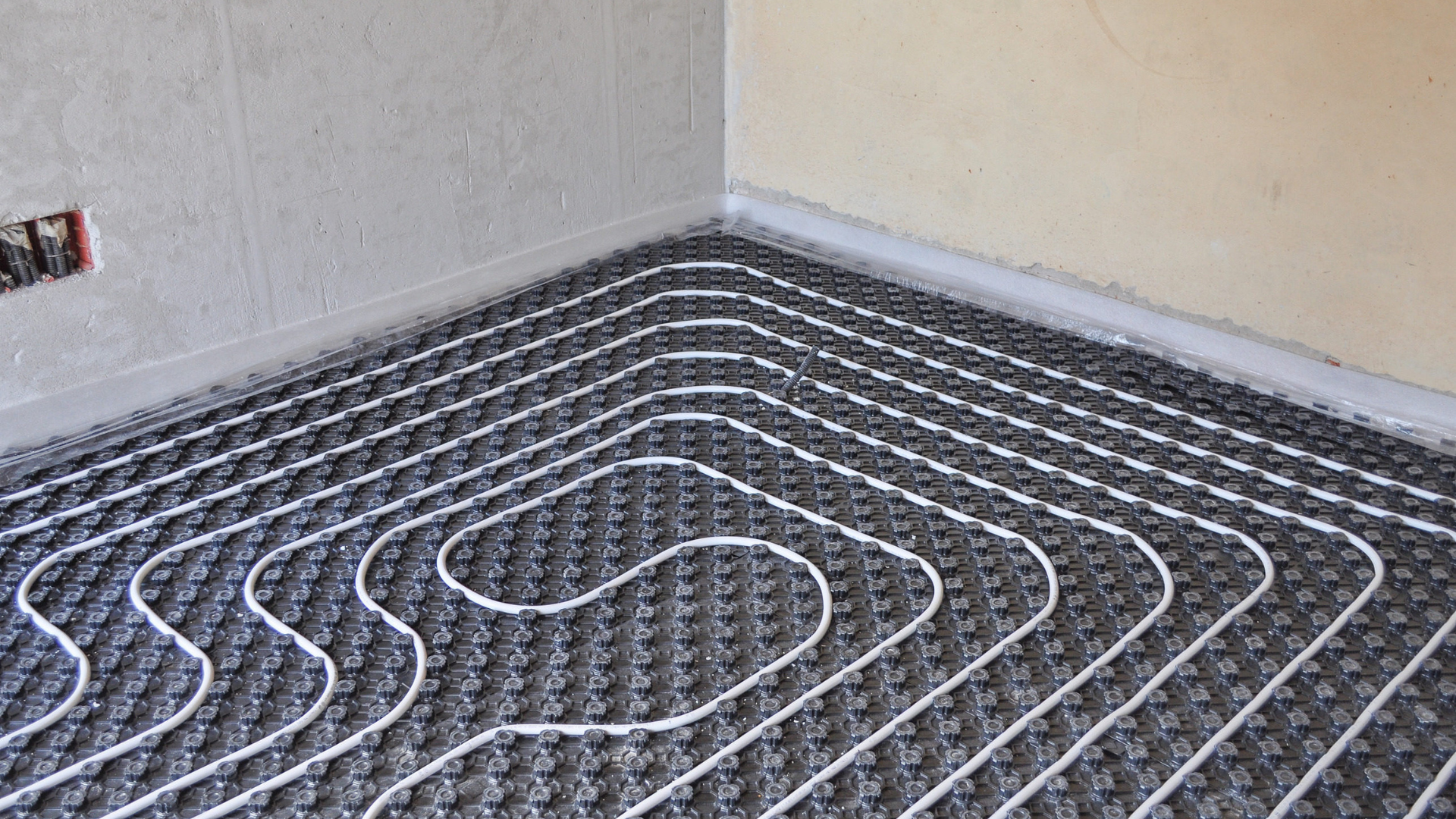 Mitsubishi heat pump on a concrete pad near a brick building.