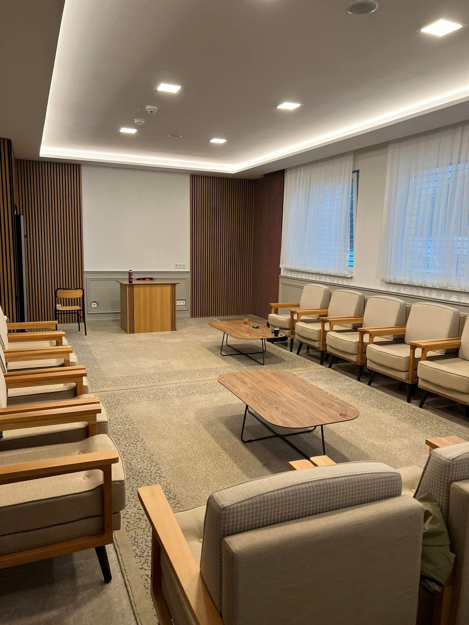 Ein Wohnzimmer mit vielen Stühlen und einem Tisch.