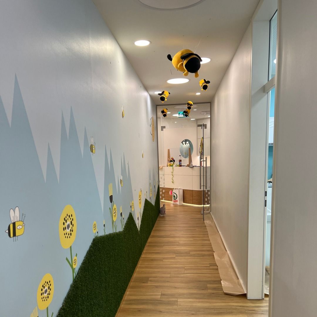 Ein Flur mit einem Gemälde von Blumen und Bienen an der Wand.