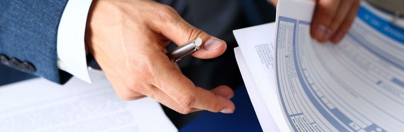 Professionista assicurativo che esamina documenti complessi di polizza