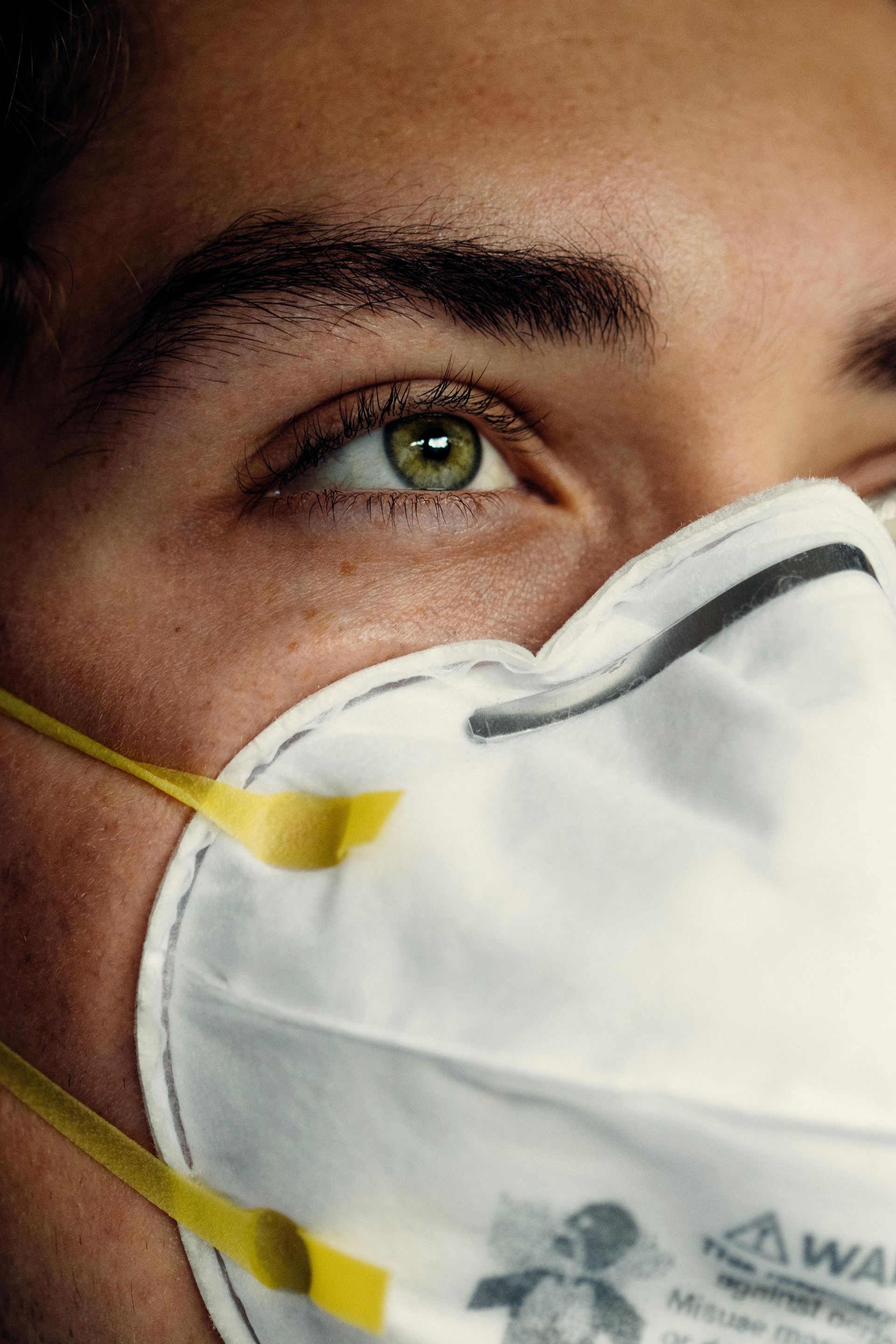 A close up of a man wearing a face mask