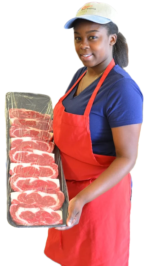 Butcher in red apron holding a tray of sliced raw meat under a white cap