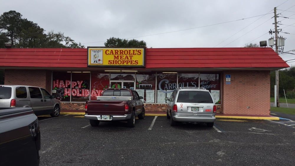Caribou’s Express storefront with red roof, parked cars, and a “Happy Holidays” window sign