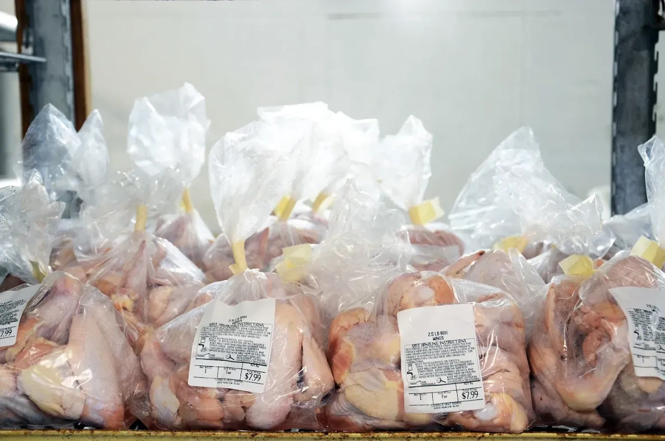 Plastic bags filled with raw chicken packed on a shelf in a storage area
