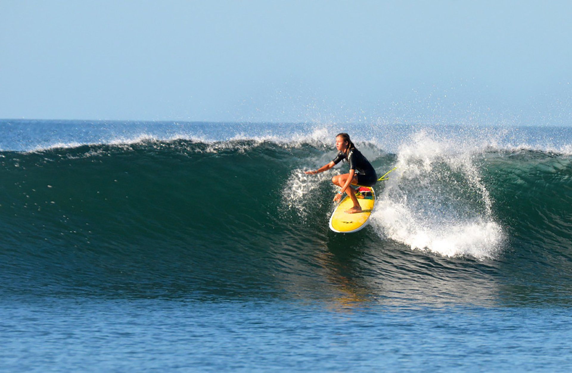A man is riding a wave on a surfboard in the ocean.