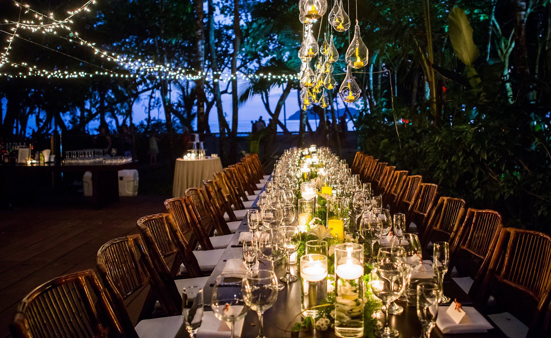 A long table with a lot of glasses and candles on it