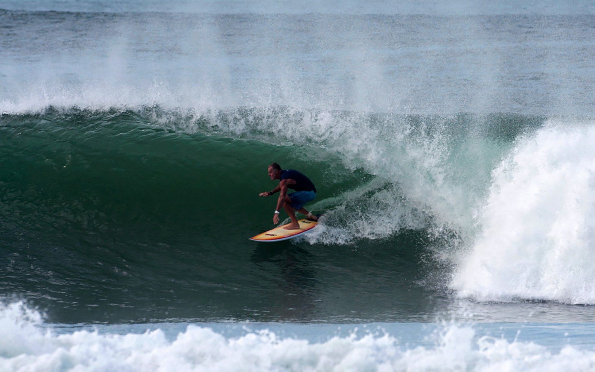 A man is riding a wave on a surfboard in the ocean.