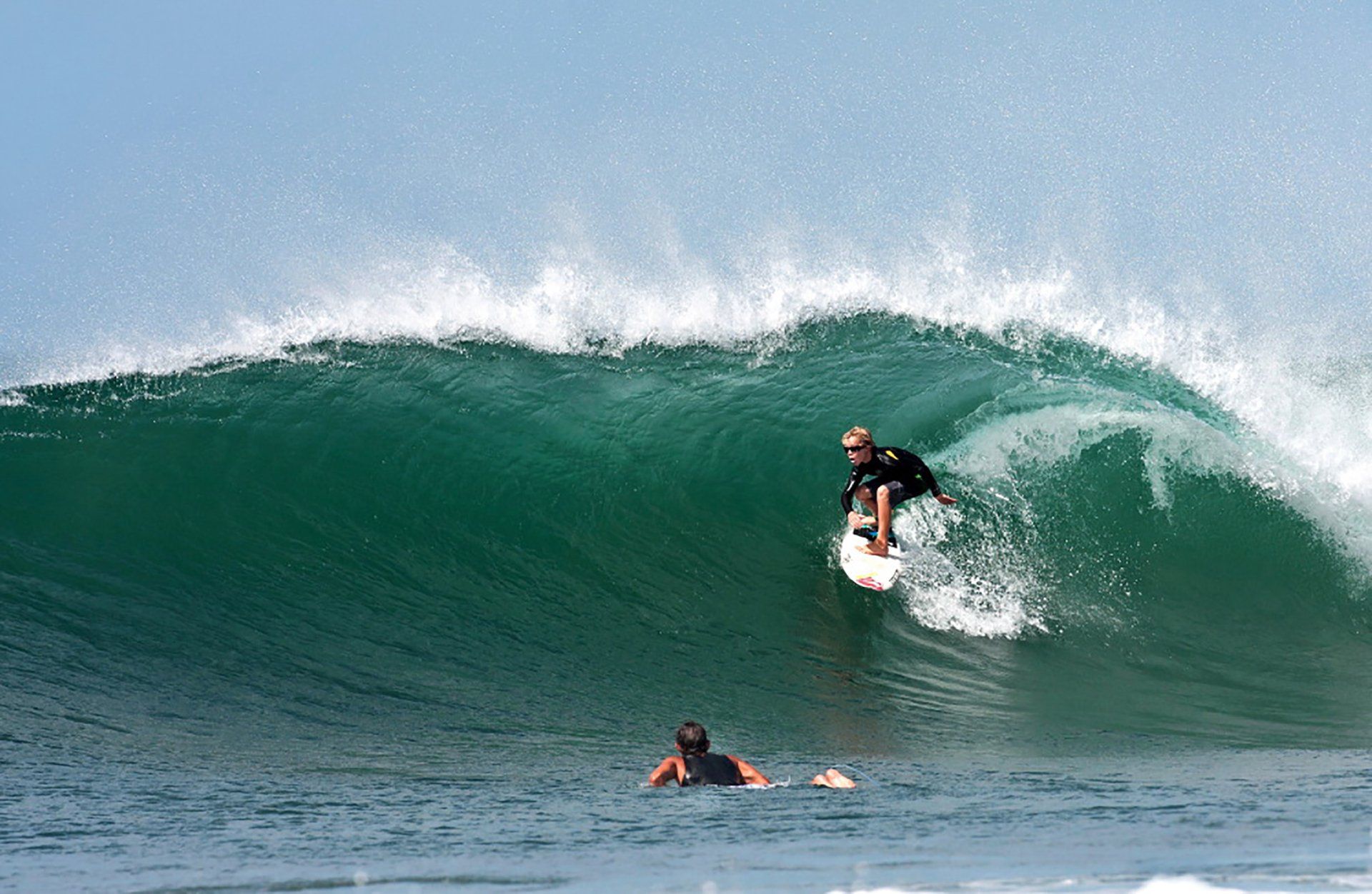 A man is riding a wave on a surfboard in the ocean.