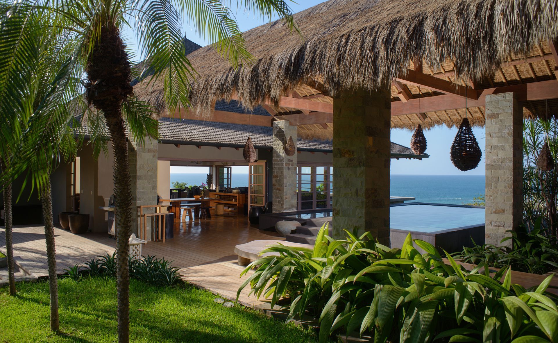 A house with a thatched roof overlooking the ocean