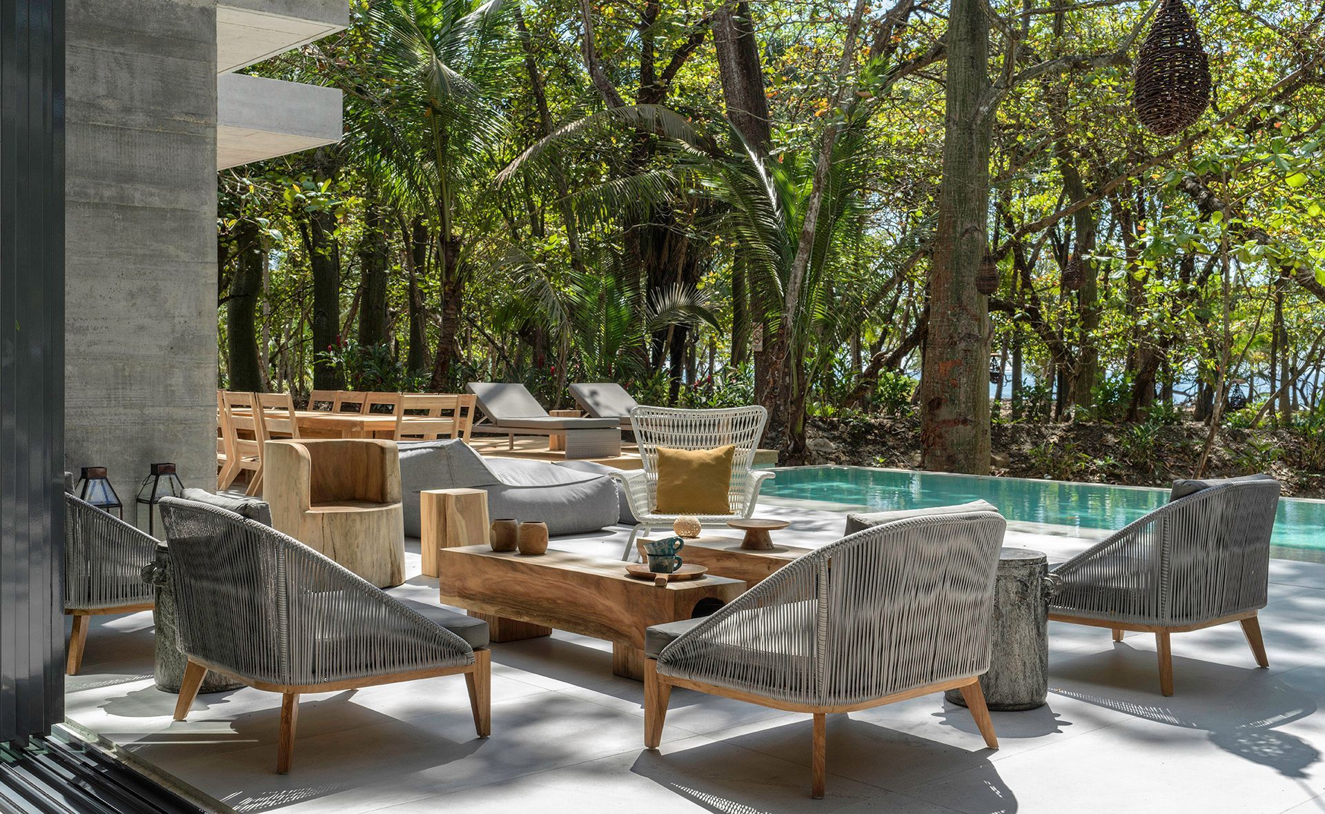 A house with a swimming pool is surrounded by trees and plants.