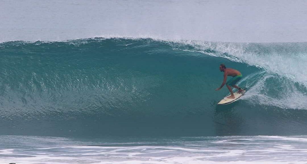 A man is riding a wave on a surfboard in the ocean.