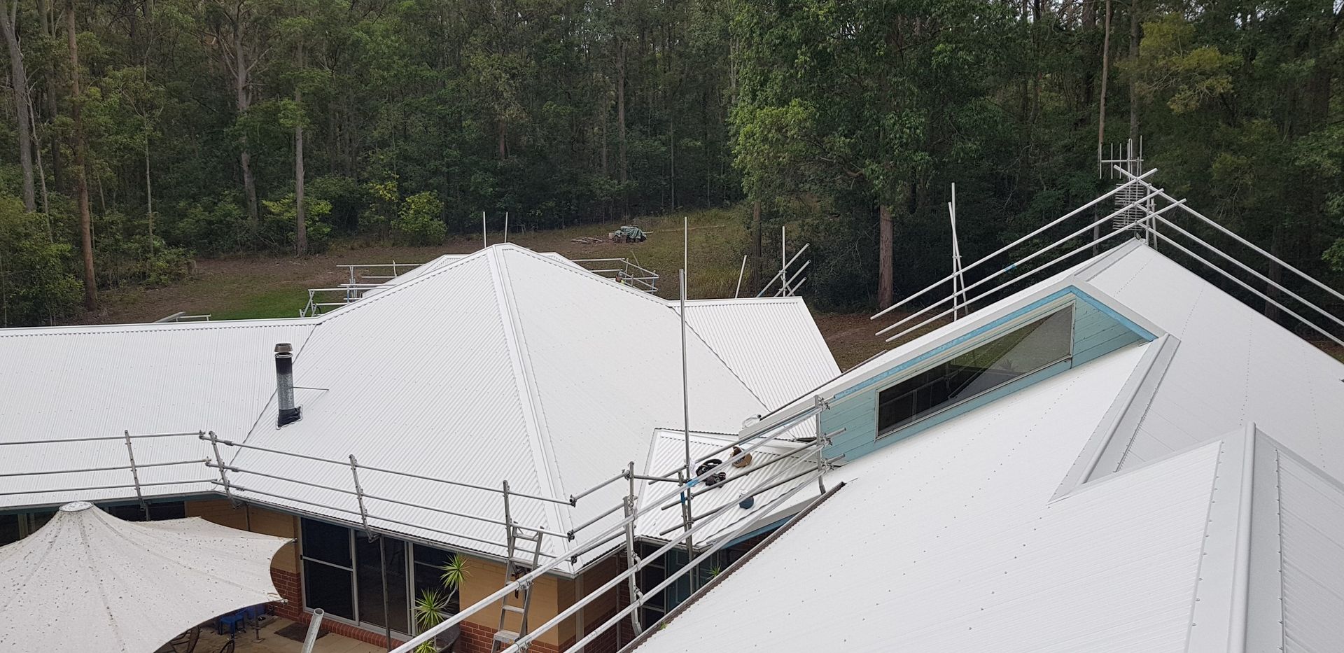 A close up of a green corrugated metal roof on a house — Glenroofing Pty Ltd In Taree, NSW