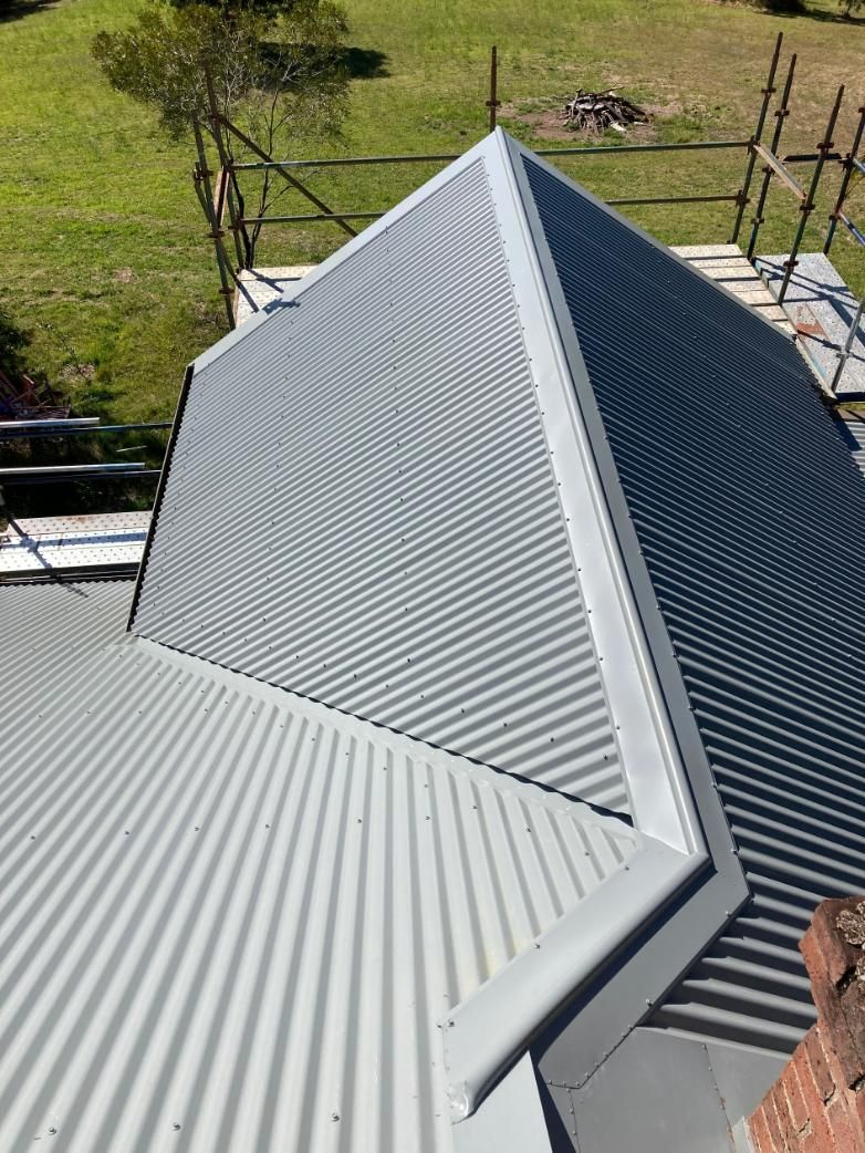 A Close Up Of A Roof With A Scaffolding In The Background — Glenroofing Pty Ltd In Taree, NSW