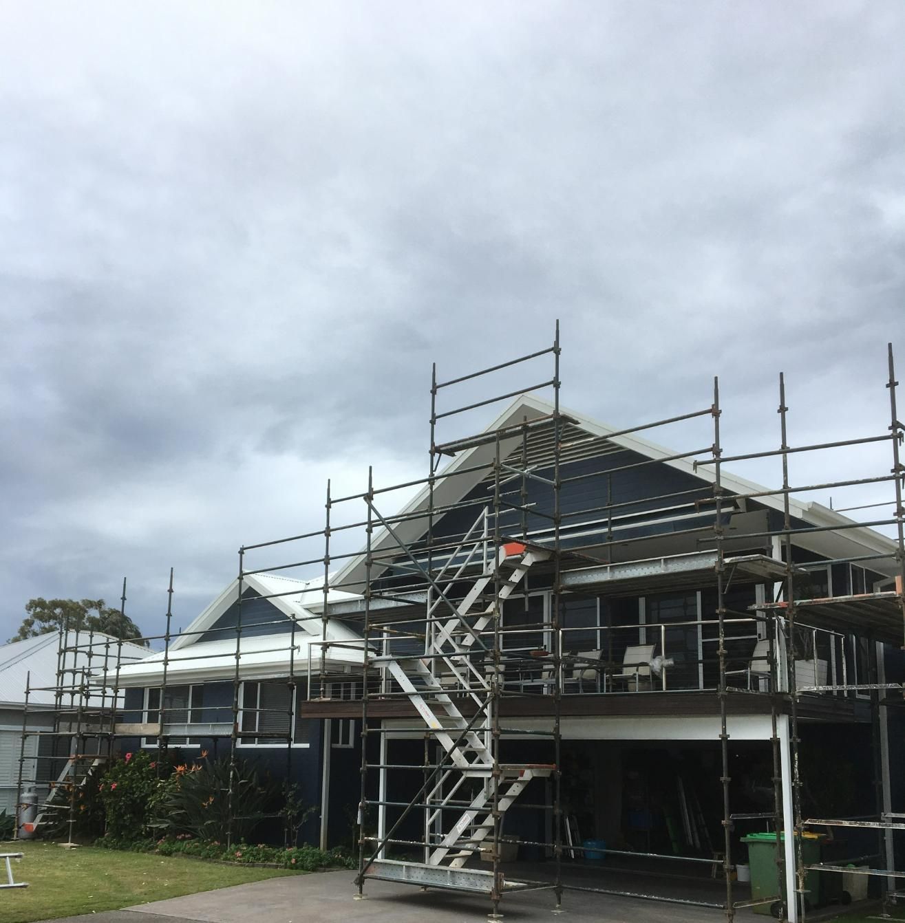A House With Scaffolding Around It And Stairs In Front Of It — Glenroofing Pty Ltd In Taree, NSW