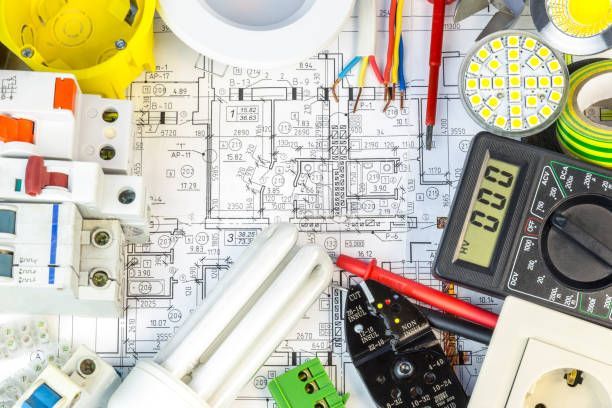 A bunch of electric tools are laying on top of a blueprint.