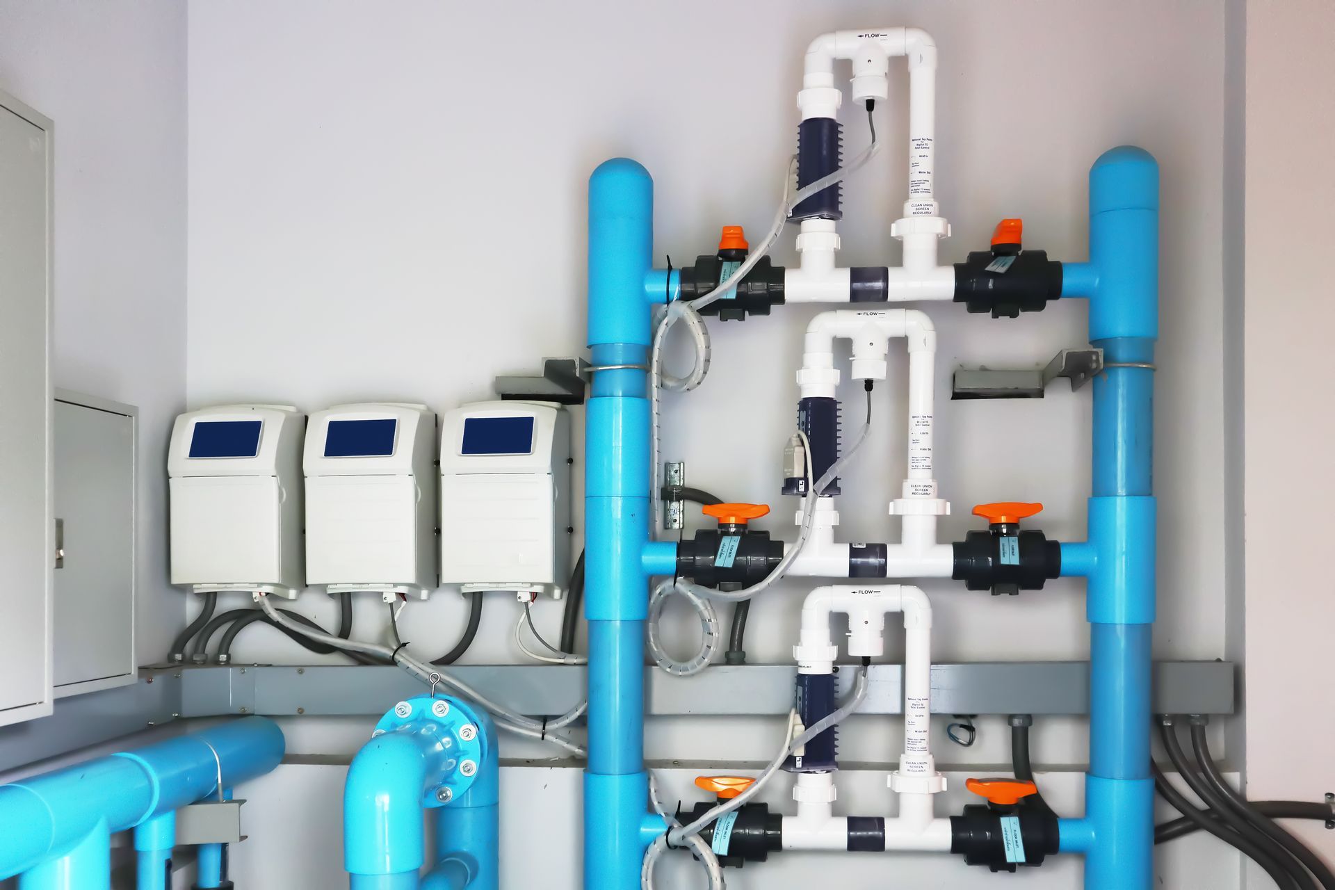 A room with a lot of pipes and meters on the wall.