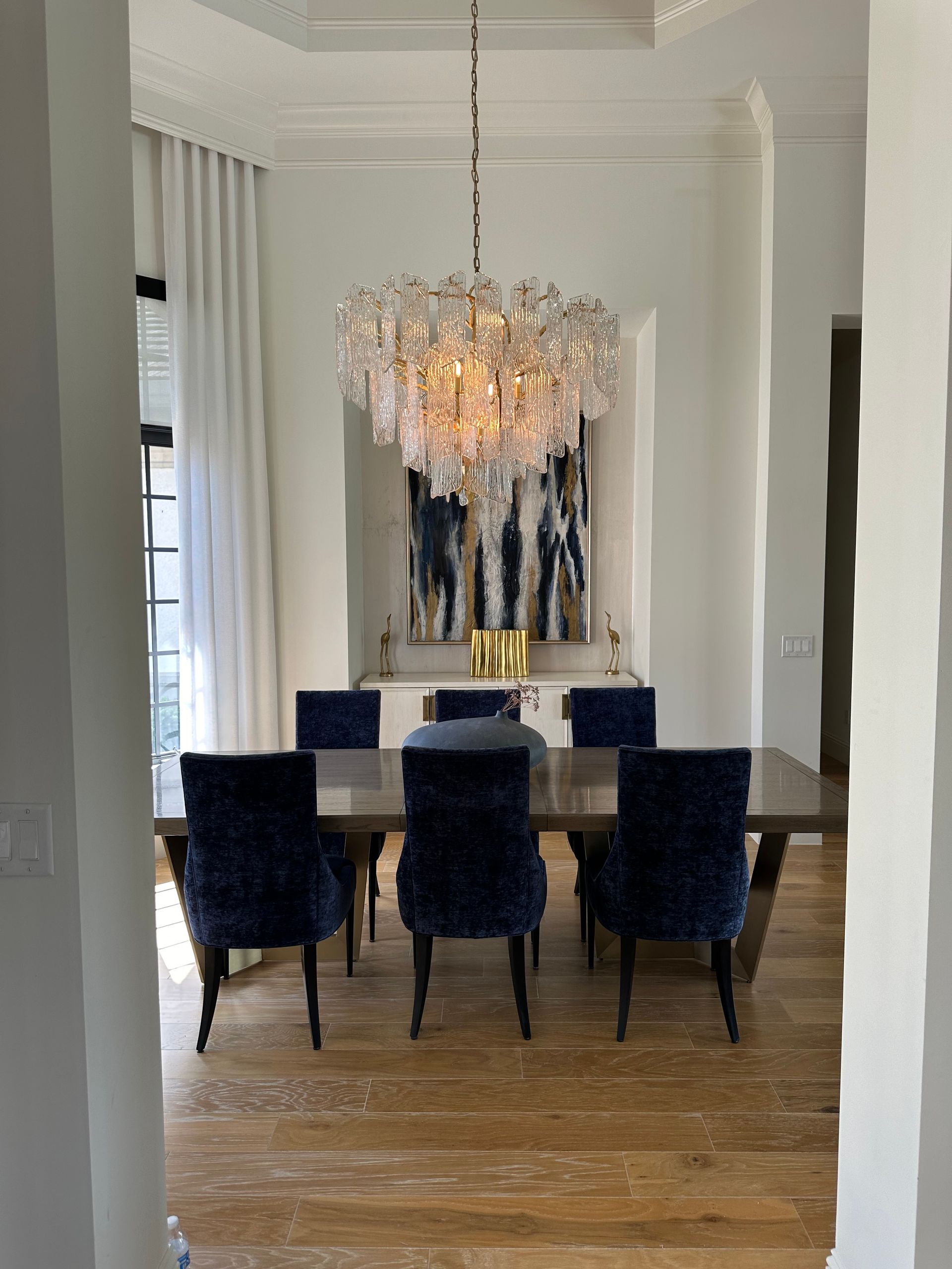 A dining room with a table and chairs and a chandelier