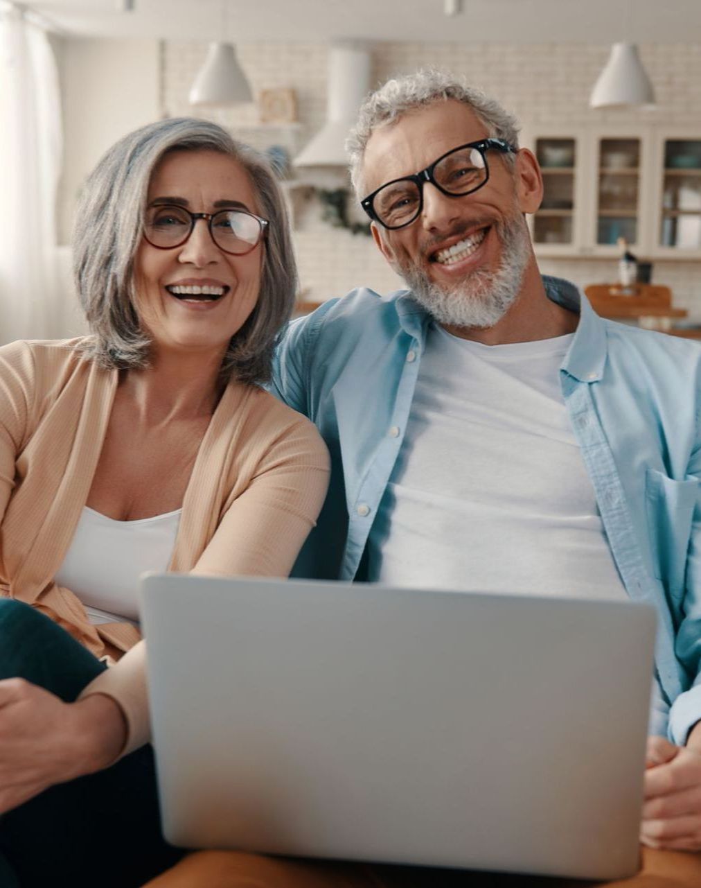 A man and a woman are sitting in front of a laptop computer.