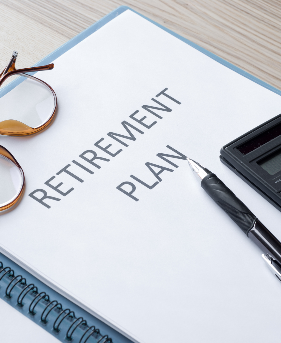 A retirement plan is written in a notebook next to a pen and calculator