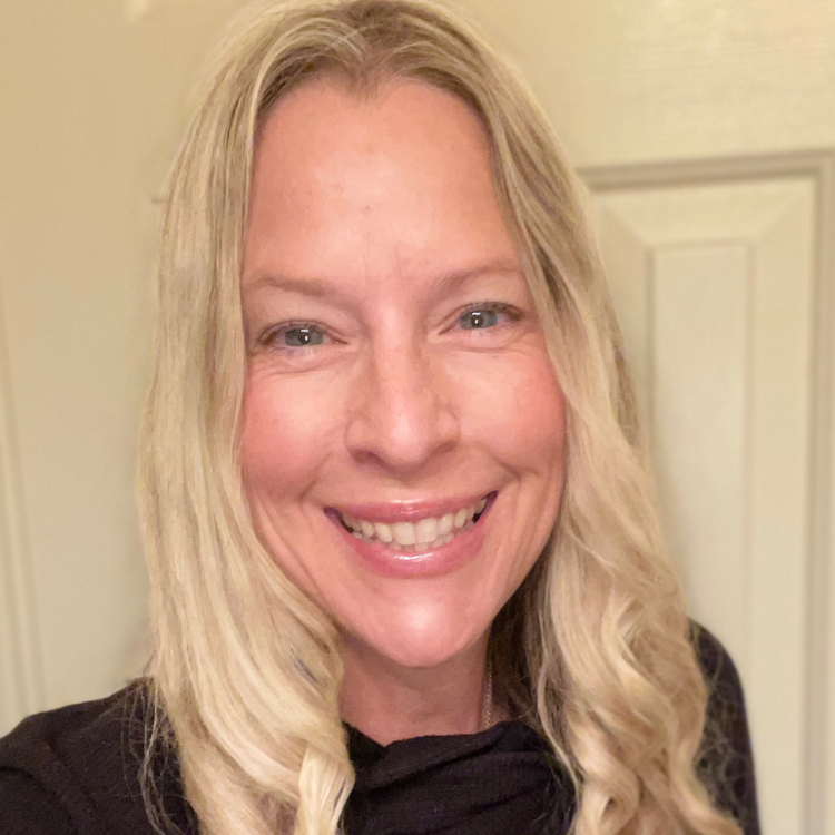 A woman with blonde hair is smiling and wearing a black shirt.