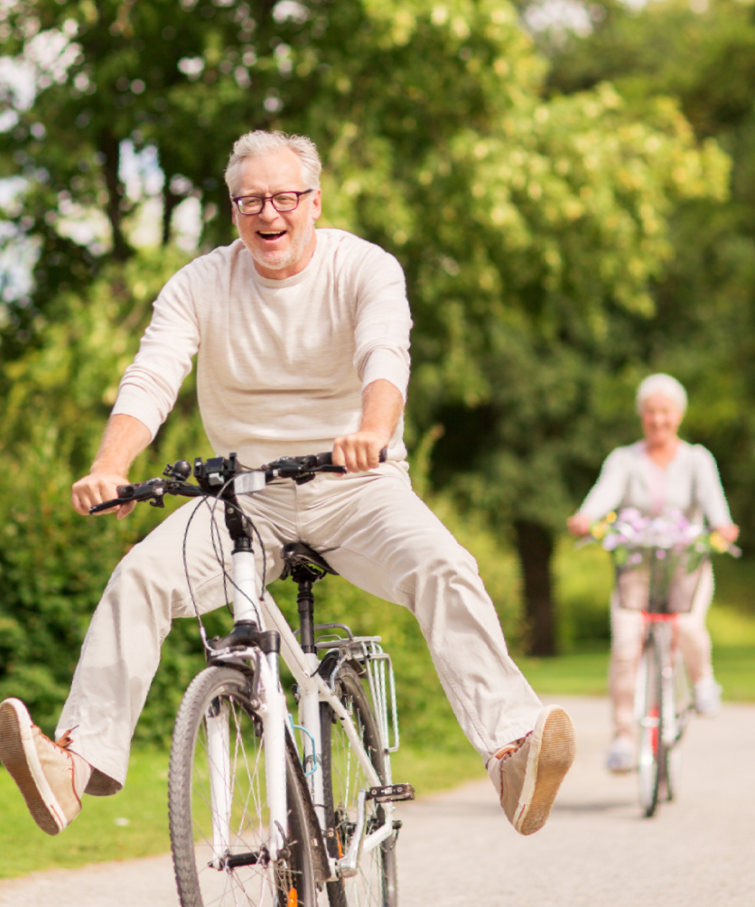 A man and a woman are riding bicycles down a path.