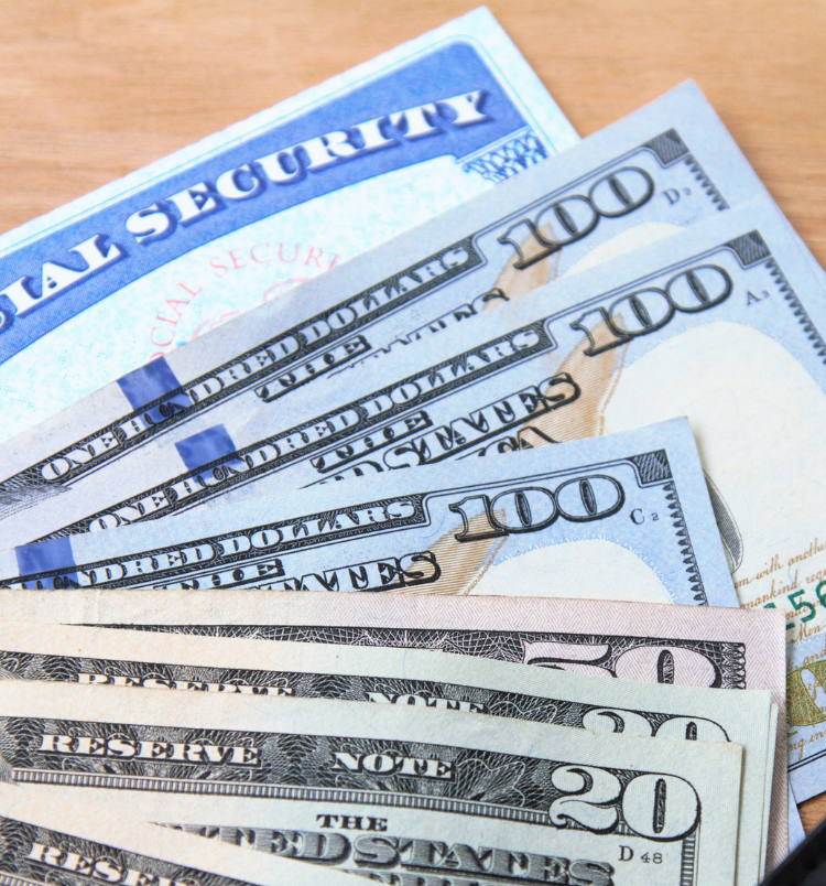 Several hundred dollar bills are stacked on top of one hundred dollar bills