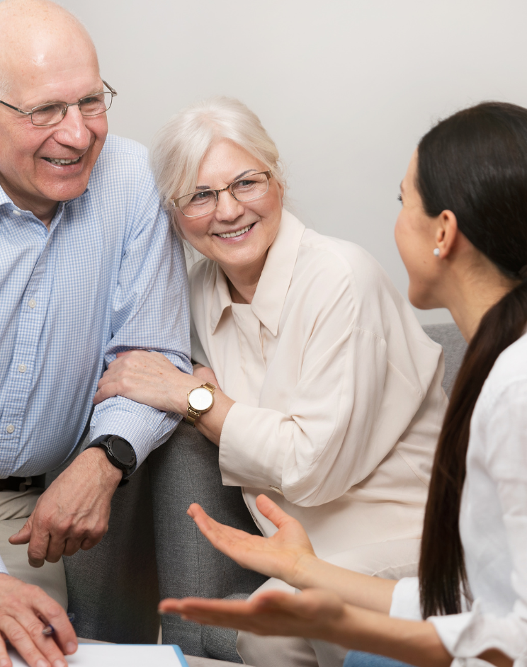 A man and woman are sitting on a couch talking to a woman