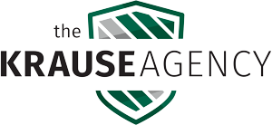 The krause agency logo is a green and white shield with a house on it.