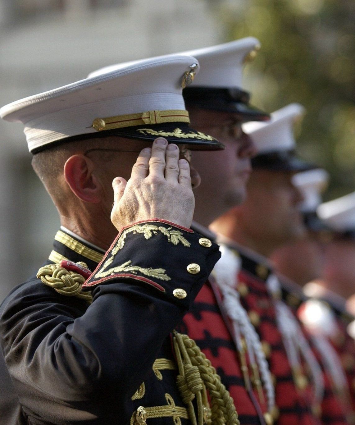 A man in a military uniform covering his face with his hand
