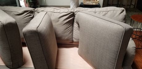 A couch with a lot of pillows on it in a living room.