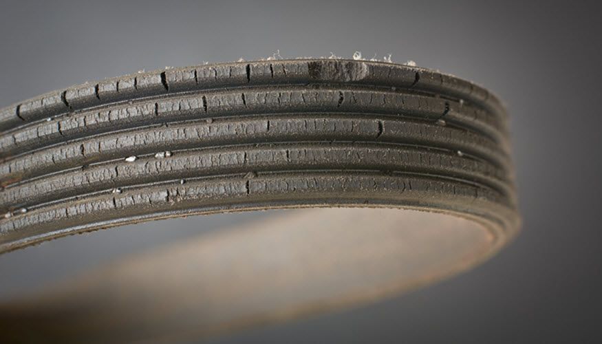A close up of a belt on a gray background. | Import Specialty Service