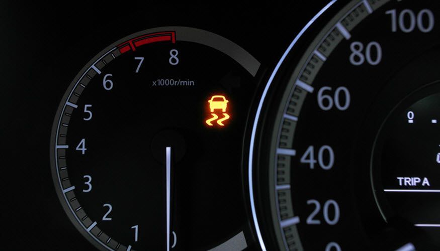 A close up of a car's dashboard with a warning light on it. | Import Specialty Service