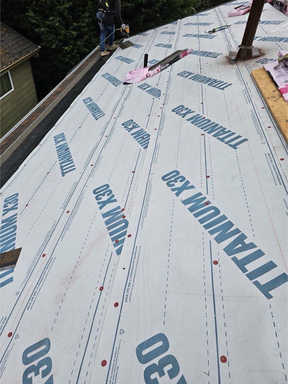 A metal roof is being installed on a house under construction.