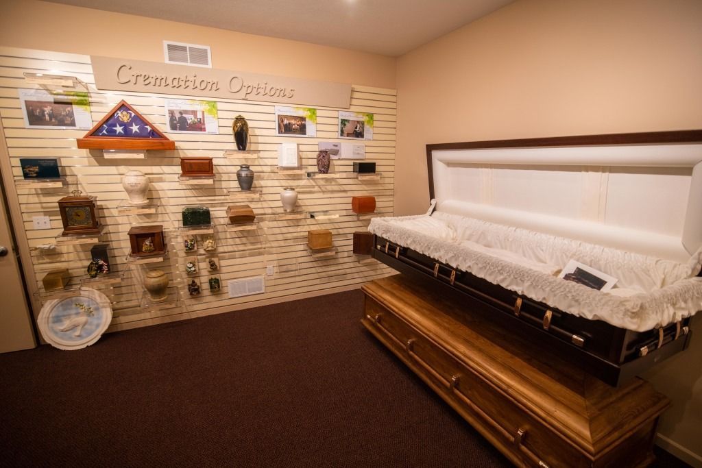 Showroom with display wall of memorial items and a casket on the right