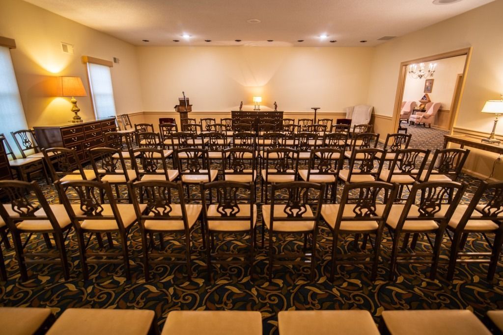 Empty conference room with rows of chairs facing the front and warm lighting