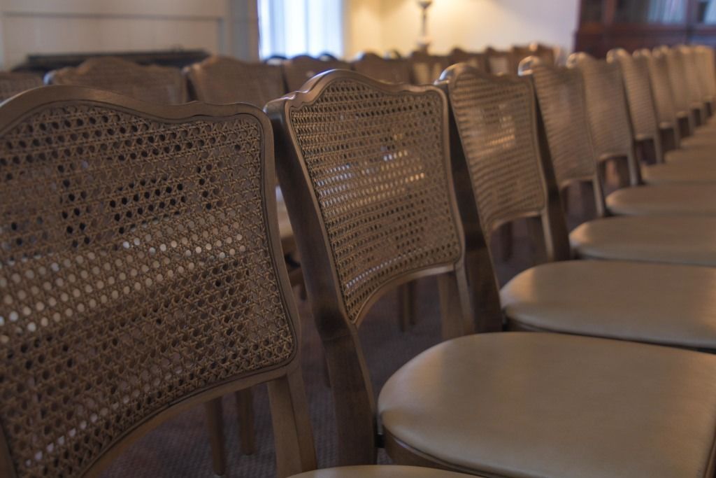 Row of woven-back chairs in a softly lit room