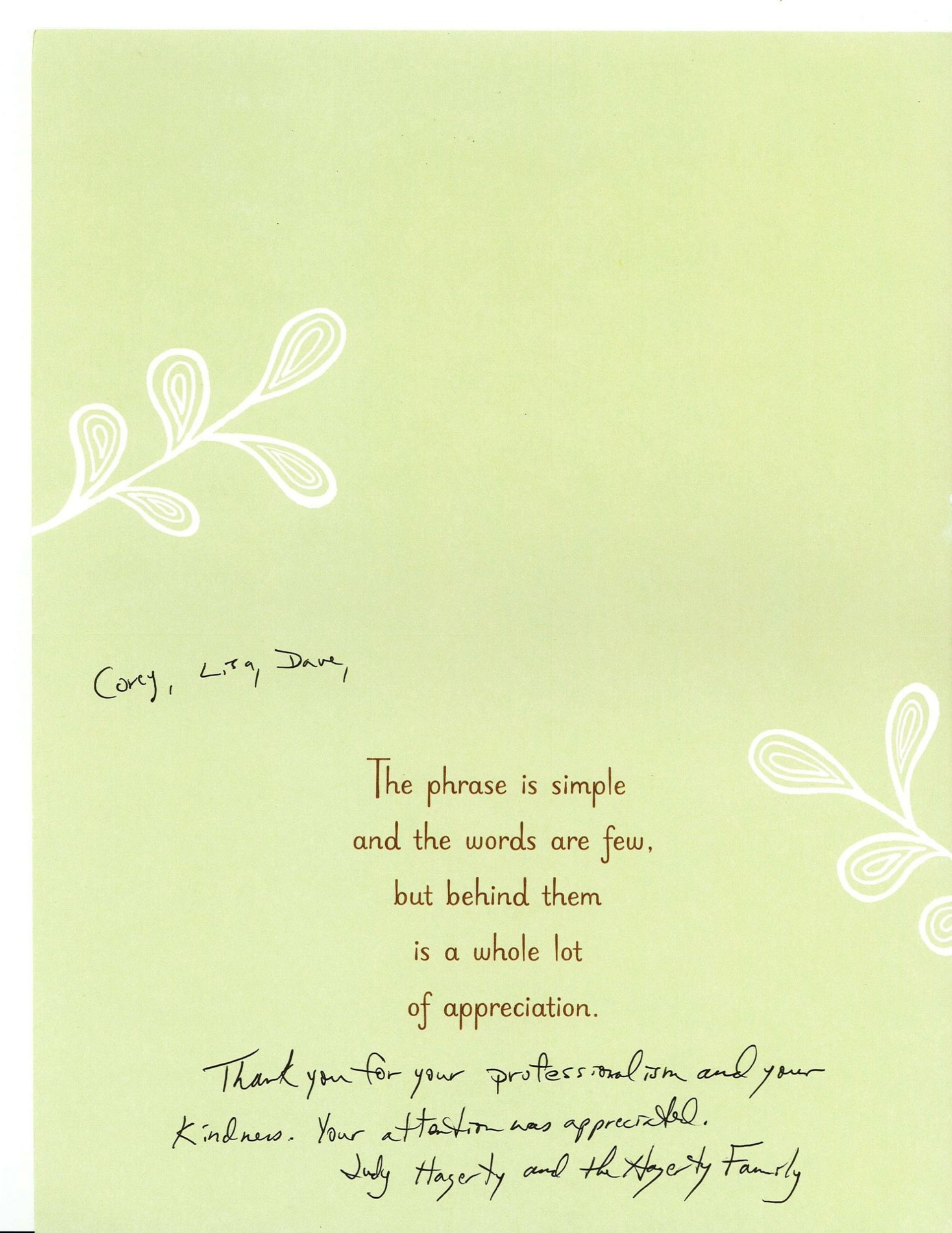 Green greeting card with white floral designs and a small handwritten message in the center.