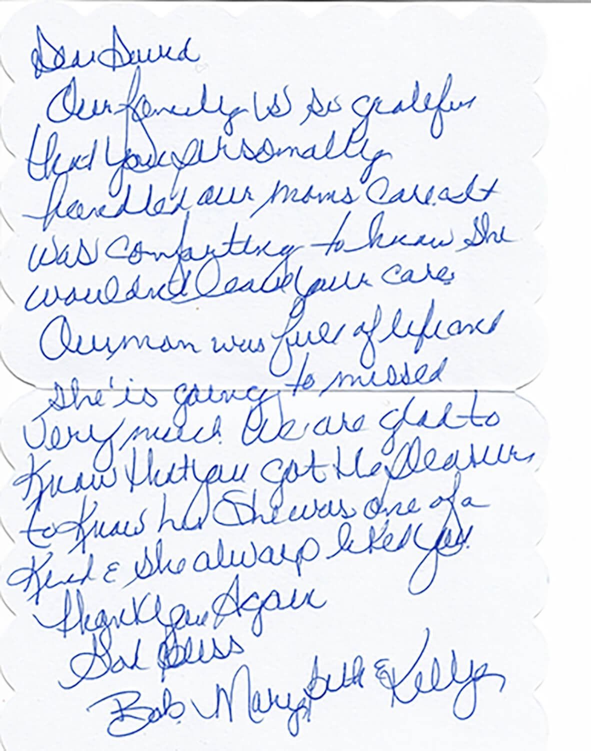 Blue cursive handwritten note on white paper, slightly blurry and slanted.