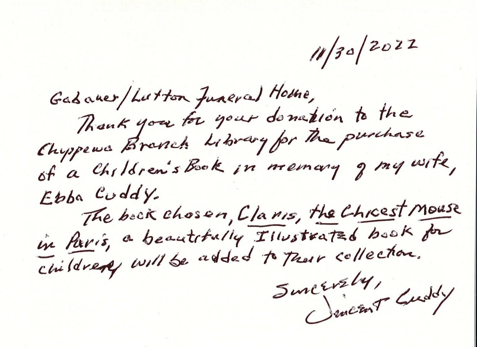 Handwritten note on white paper with black ink, mentioning a gift for a children’s book fund and signed at the bottom