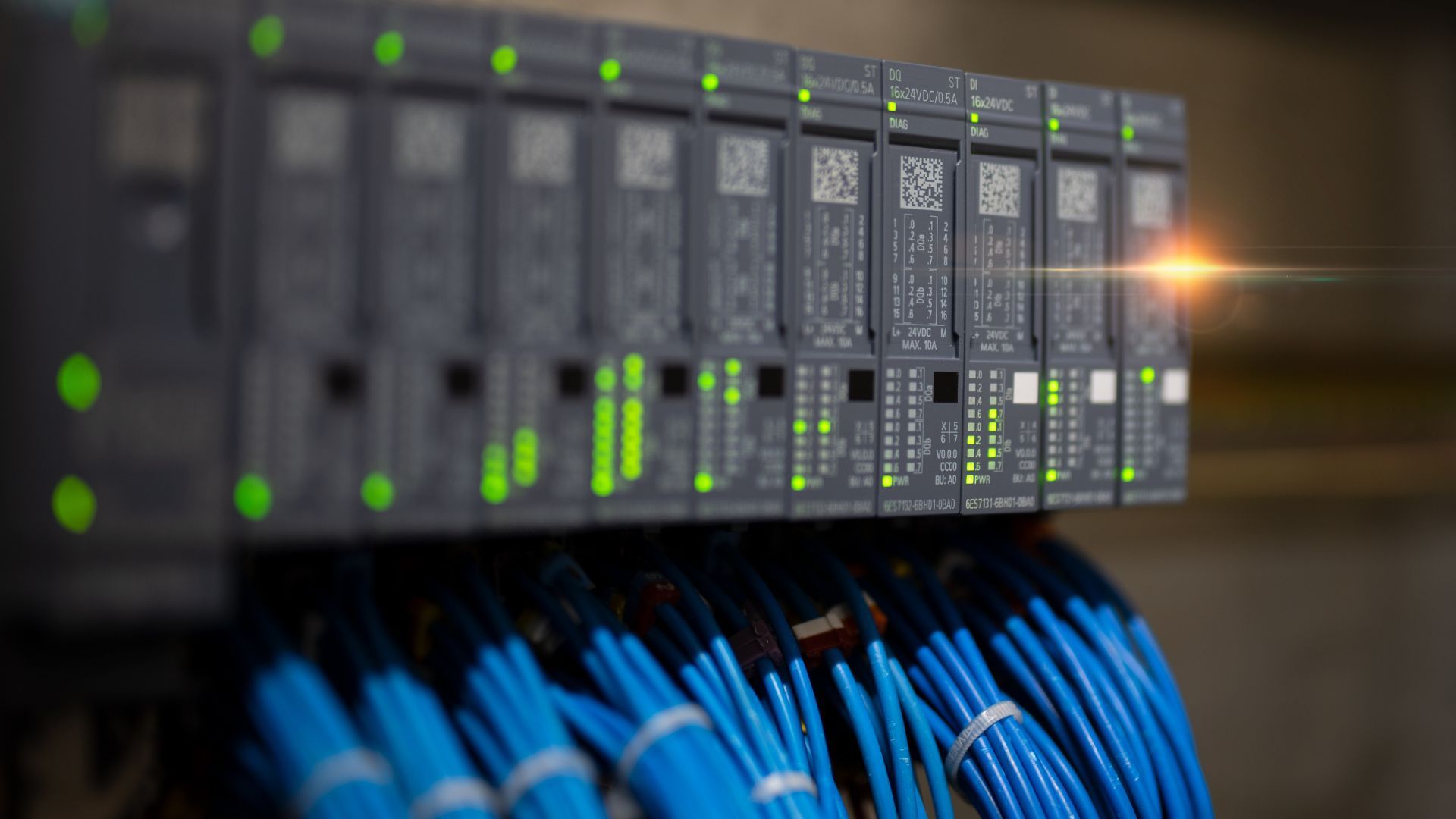 Network server rack with blinking green lights and blue Ethernet cables connected underneath