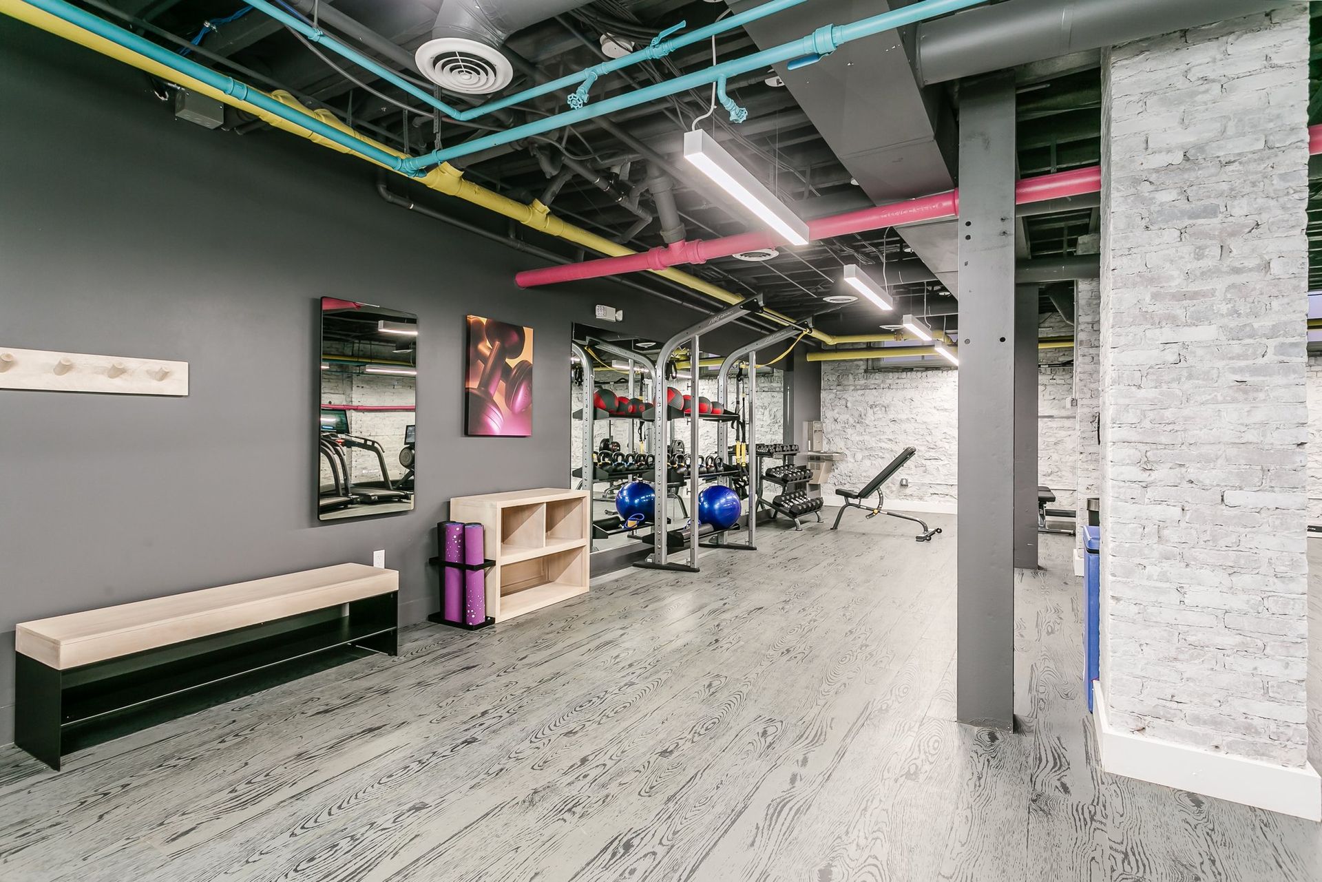 Fitness center wall with yoga balls, kettlebells, free weights, and more