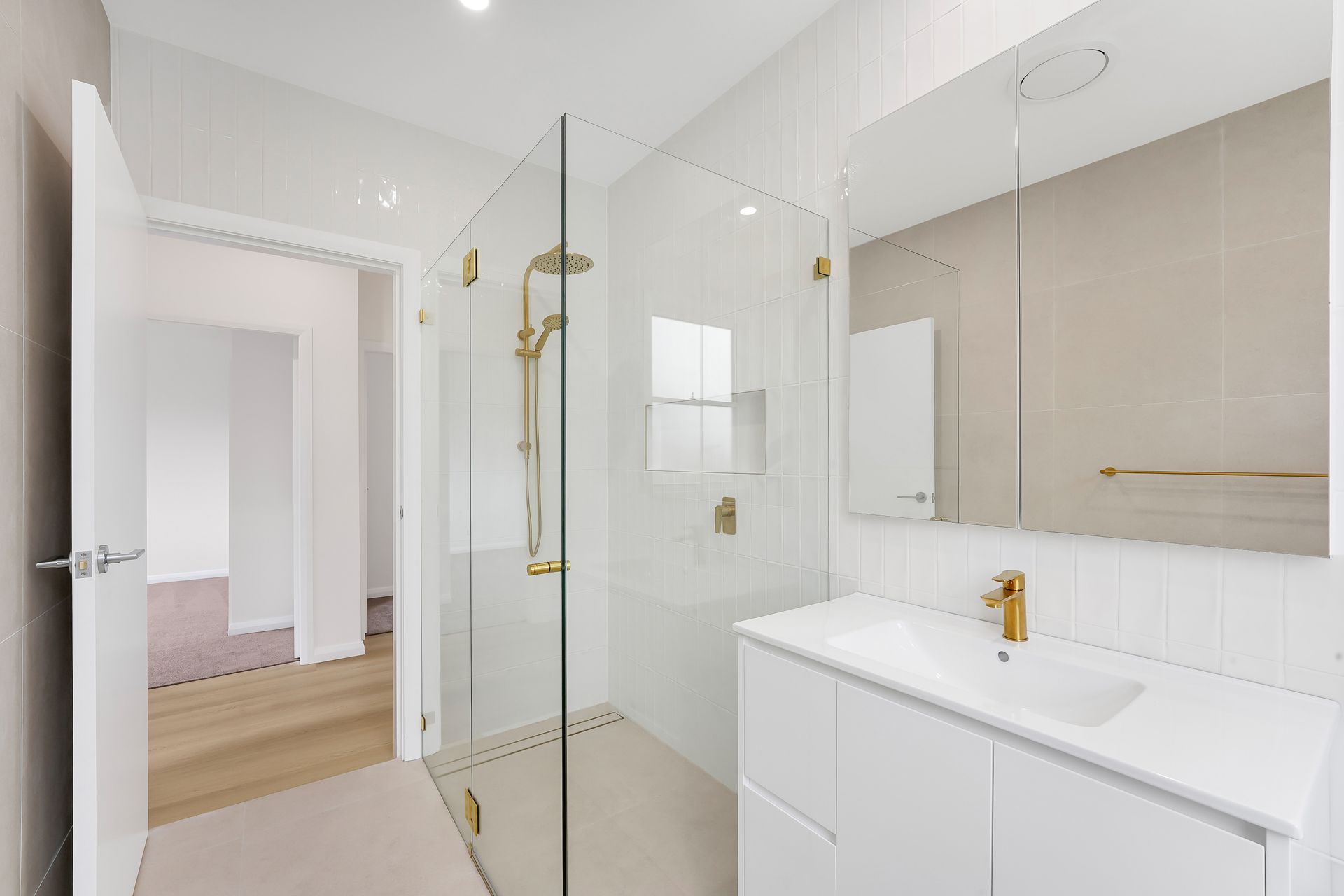 Ensuite renovation by Nique Building Central Coast — wall hung vanity, gold tapware and frameless shower