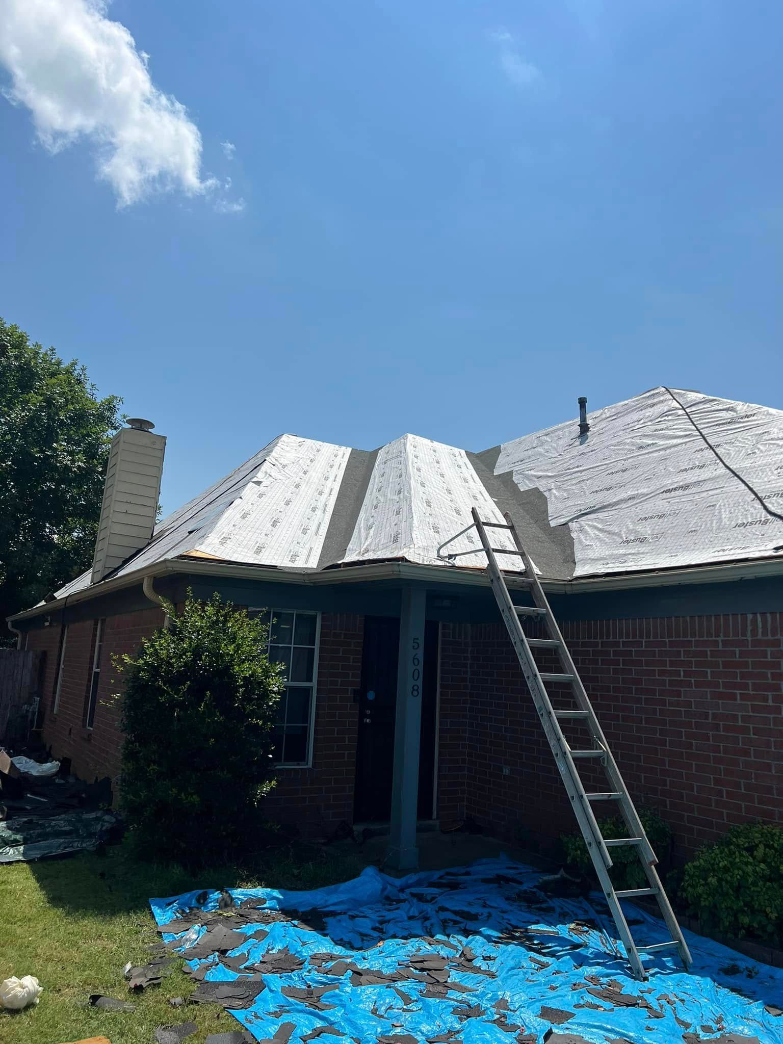 House roof under repair with ladder, blue tarp, and shingles scattered in the front yard