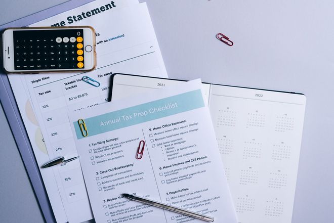 Calculator and worksheets on a desk, suggesting financial planning or accounting tasks