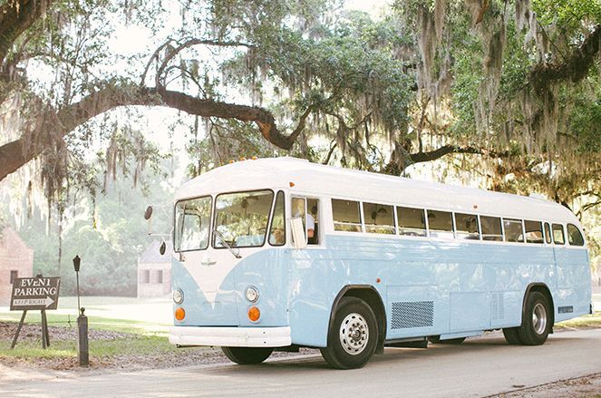 A blue and white bus is parked on the side of the road.