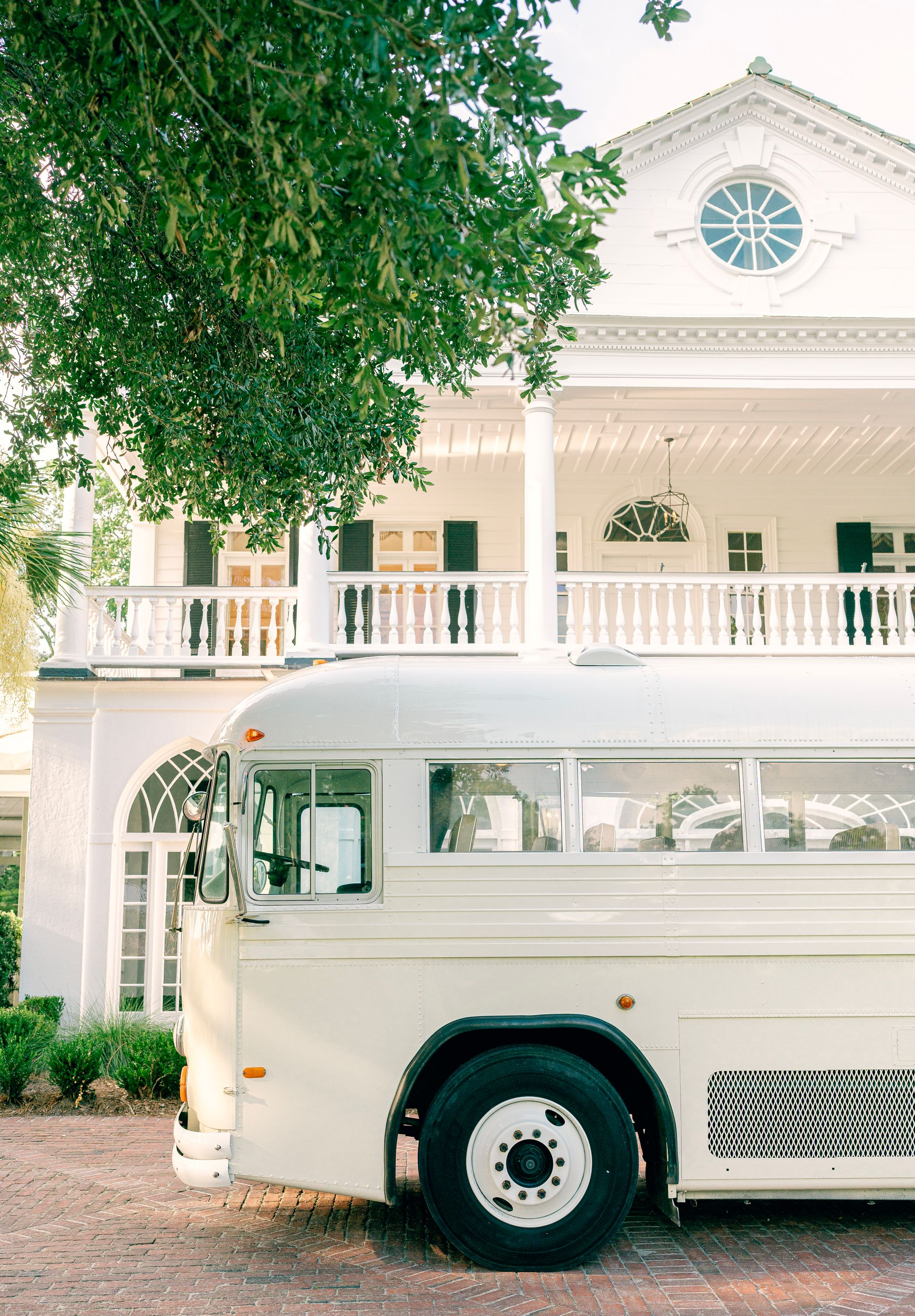 A cream vintage bus is parked on the side of a road at Lowdnes Grove.