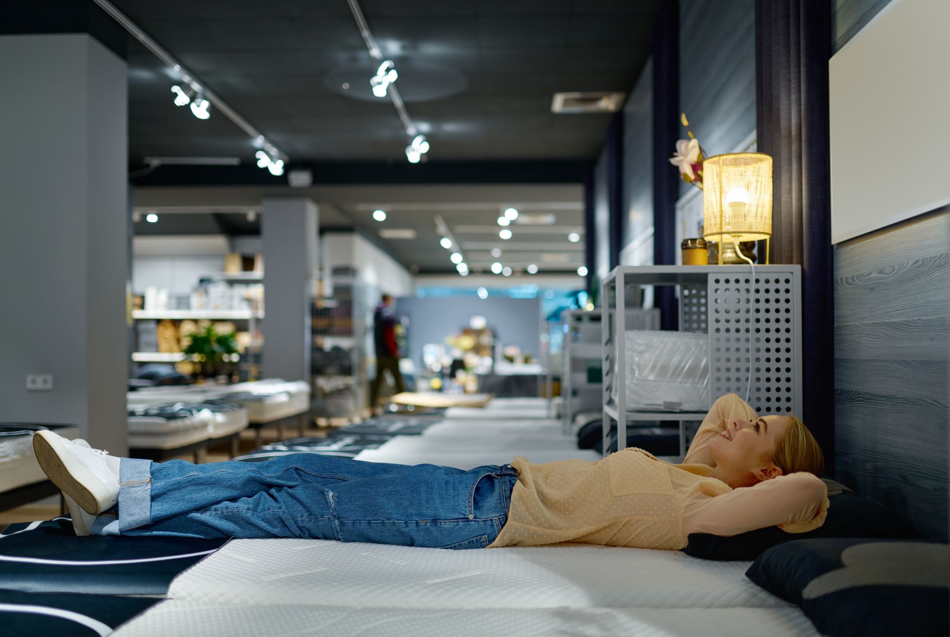 Woman choosing bed mattress in furniture store. Woman choosing bed mattress in furniture store.