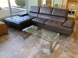 A living room with a couch , ottoman , and coffee table.